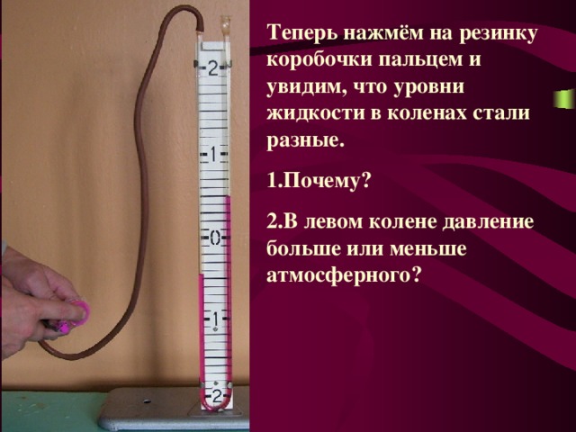 Теперь нажмём на резинку коробочки пальцем и увидим, что уровни жидкости в коленах стали разные. Почему? В левом колене давление больше или меньше атмосферного? 