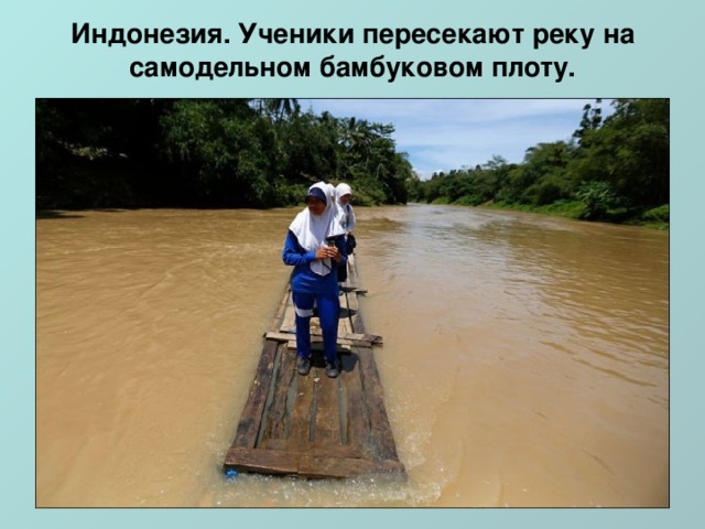 Индонезия. Ученики пересекают реку на самодельном бамбуковом плоту.   