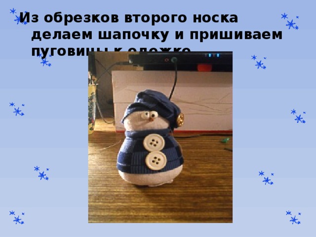 Из обрезков второго носка делаем шапочку и пришиваем пуговицы к одежке 